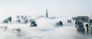 Skyscrapers emerge from a sea of clouds, suggesting a city above the clouds