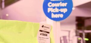 Deliveroo bag with a delivery receipt, "Courier Pick-up here" sign in the background