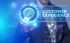 Hand interacting with a holographic interface displaying "CUSTOMER EXPERIENCE" and a magnifying glass icon
