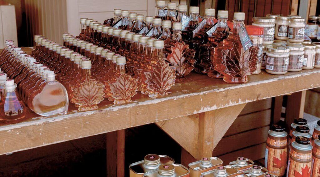 Maple syrup and other CPG products displayed on a rustic wooden table