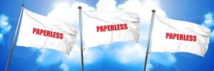 Three white flags with "PAPERLESS" in red text wave against a bright blue sky with white clouds