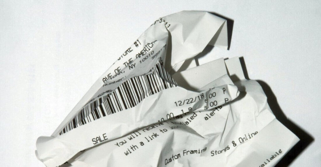 Crumpled paper receipt with a barcode, date 12/22/18, and text about a sale and online stores