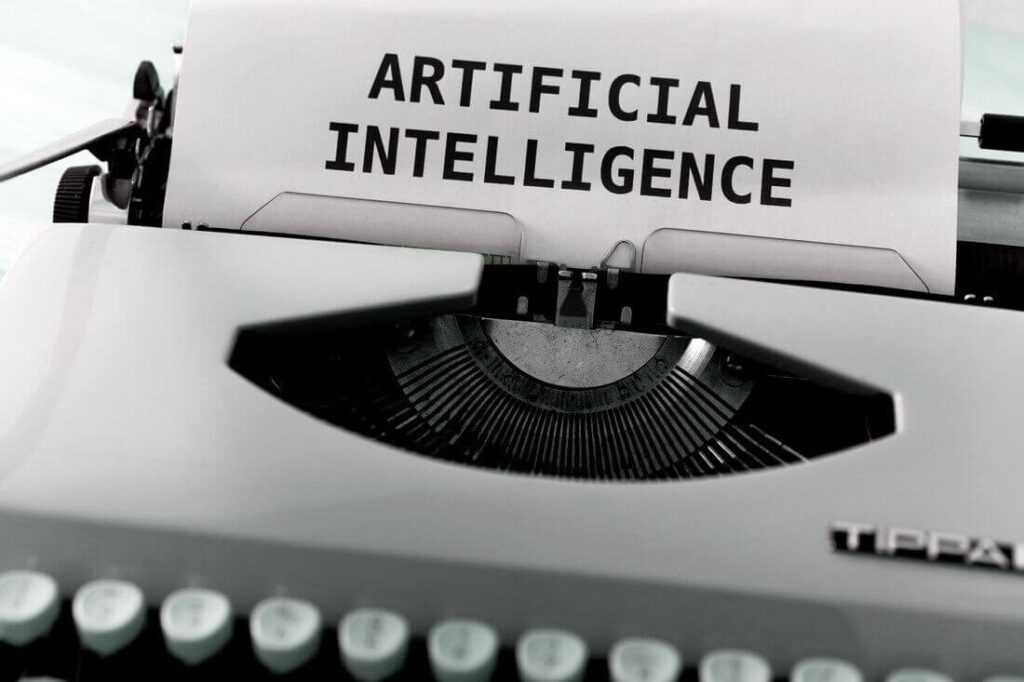 ARTIFICIAL INTELLIGENCE" typed on paper in a vintage typewriter, symbolizing AI technology