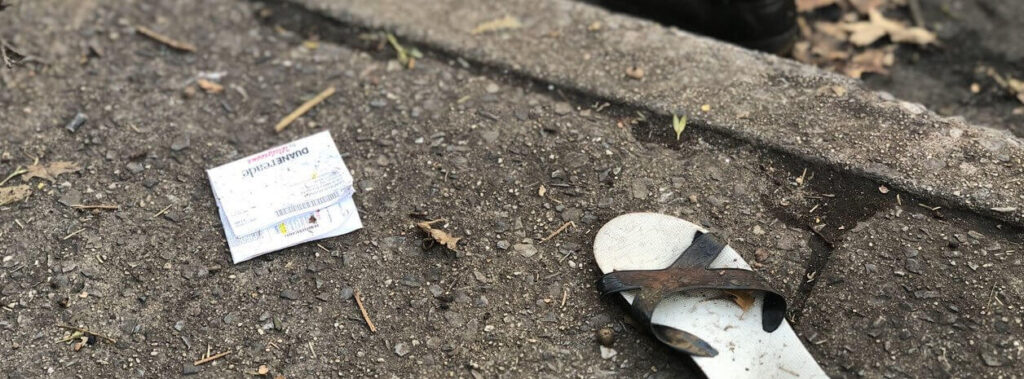 A discarded receipt and a flip-flop on a dirty concrete surface