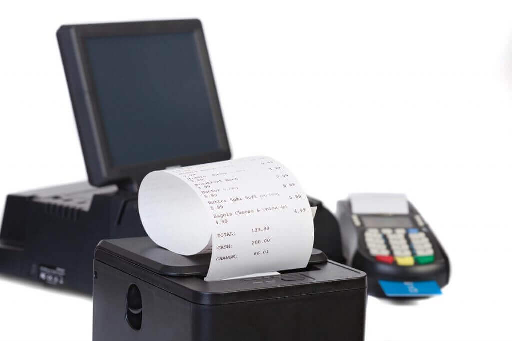 A POS system with a receipt printer showing a bill and a credit card terminal
