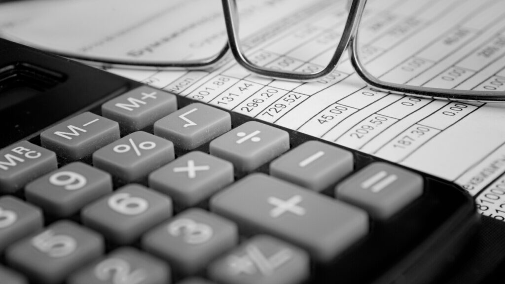 Calculator, glasses, and a financial spreadsheet, representing accounting and OCR scanning