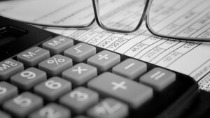 Calculator, glasses, and a financial spreadsheet, representing accounting and OCR scanning